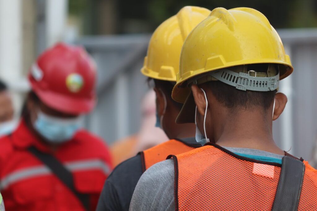 workers in hard hats wearing high-visibility jackets
